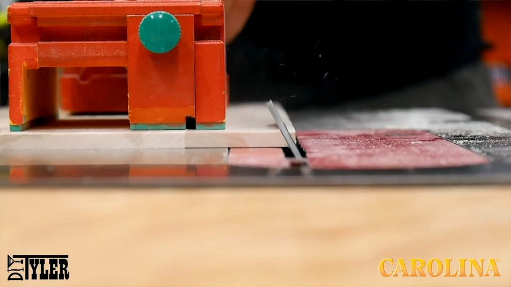 man running wood board through angled table saw