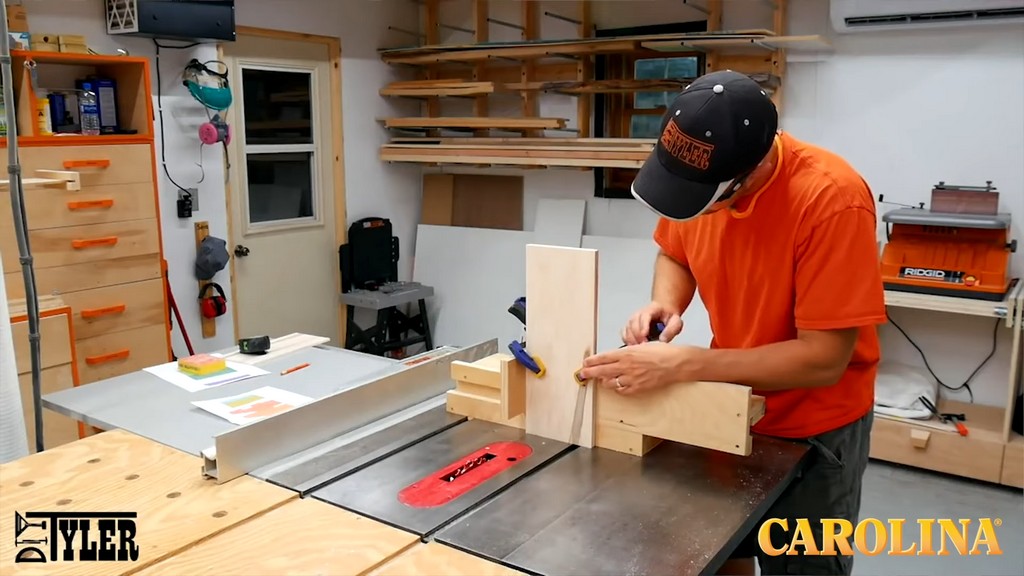 man running wood board through table saw with help of jig