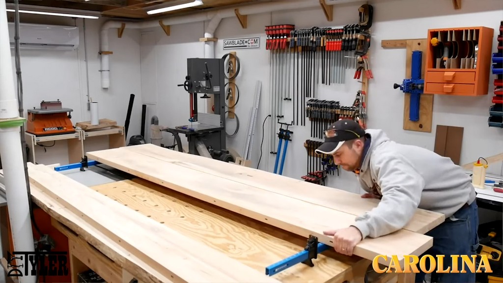 man clamping boards for table together on worktable