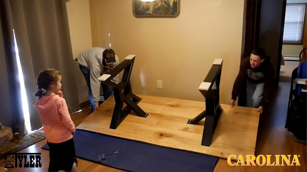 two men flipping over finished ambrosia wood table