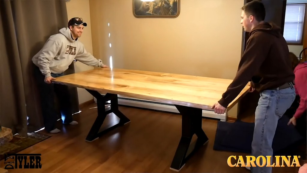 two men flipping over finished ambrosia wood table